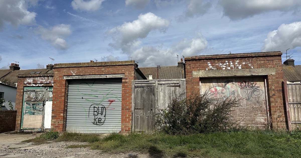 A metal roller shutter covered in spray paint tags