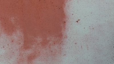 A rusty steel surface being cleaned to bright metal