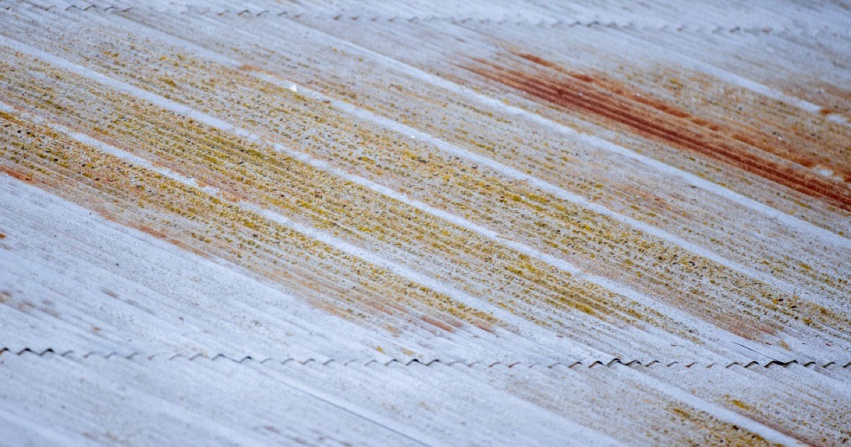 A rusty steel surface being cleaned to bright metal