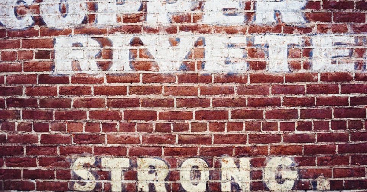 Graffiti sprayed across a red brick wall